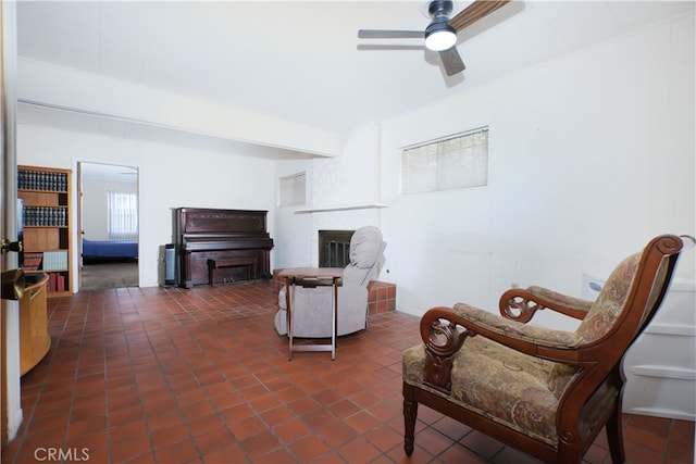 living room featuring a fireplace and a ceiling fan