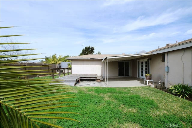 rear view of property with french doors, a lawn, a patio, and fence