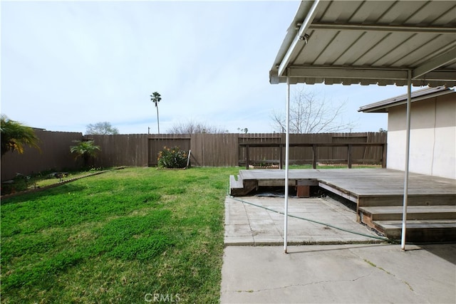 view of yard featuring a patio area, a fenced backyard, and a wooden deck