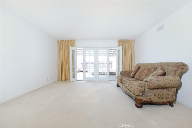 living area featuring french doors, carpet flooring, and visible vents