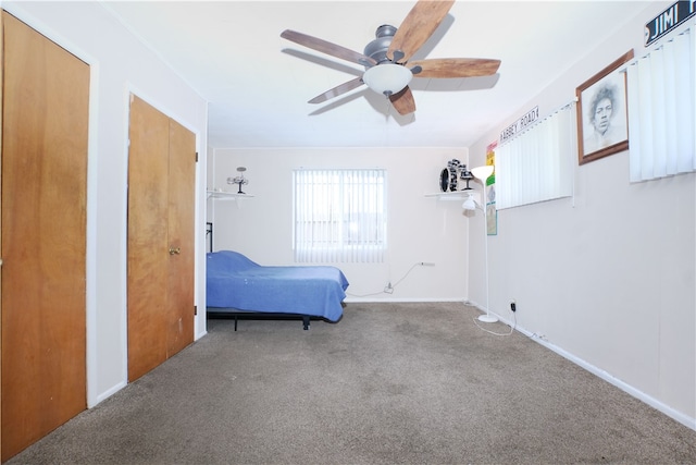 carpeted bedroom featuring a ceiling fan and multiple closets