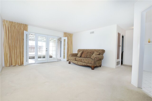 carpeted living room featuring french doors and visible vents