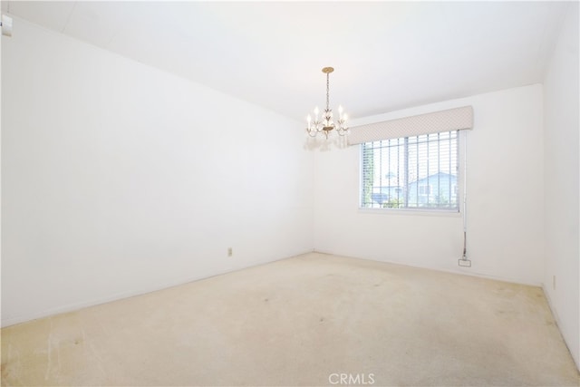 unfurnished room with carpet floors and a notable chandelier