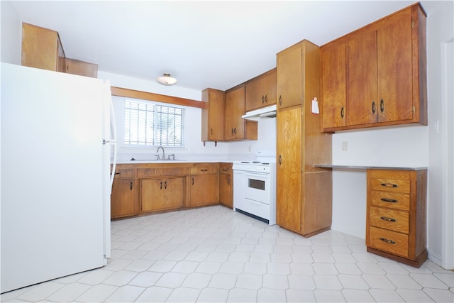 kitchen with white appliances, under cabinet range hood, brown cabinets, and a sink