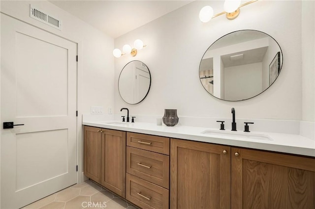 bathroom with double vanity, visible vents, a sink, and tile patterned floors