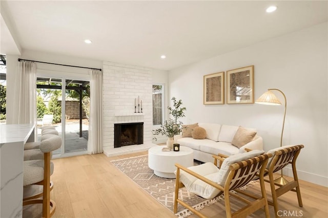 living room with baseboards, light wood finished floors, a fireplace, and recessed lighting