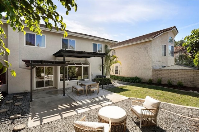 back of property featuring a patio area, a lawn, stucco siding, and a pergola