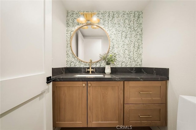 bathroom with wallpapered walls and vanity