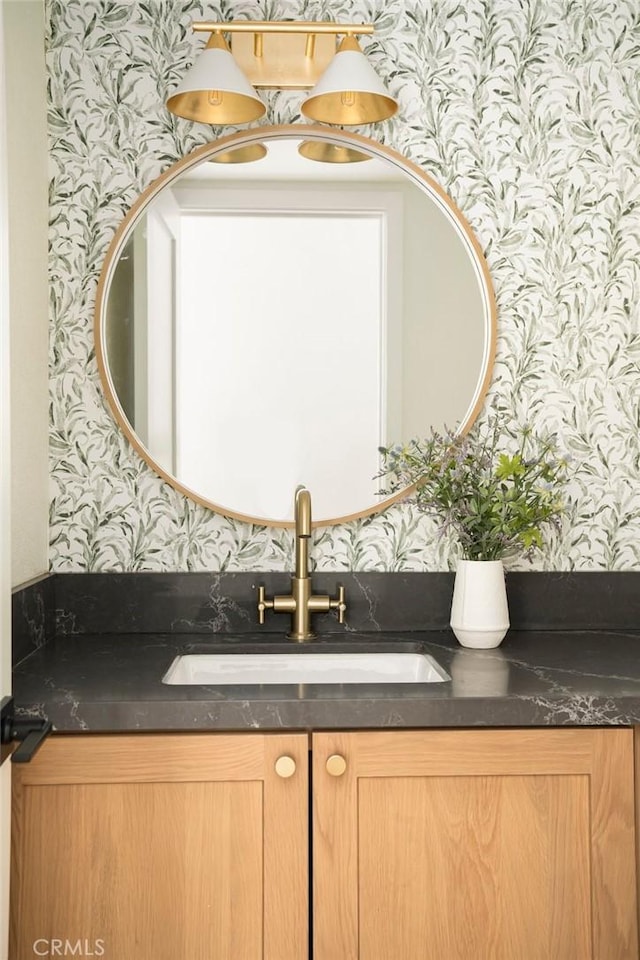 bathroom with vanity and wallpapered walls