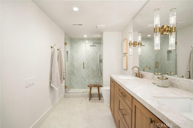 full bath with toilet, double vanity, a sink, and visible vents