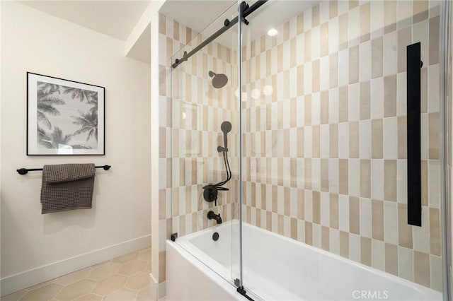 bathroom with tile patterned floors, baseboards, and bath / shower combo with glass door