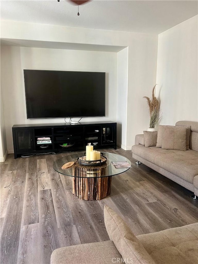 living area with baseboards and wood finished floors