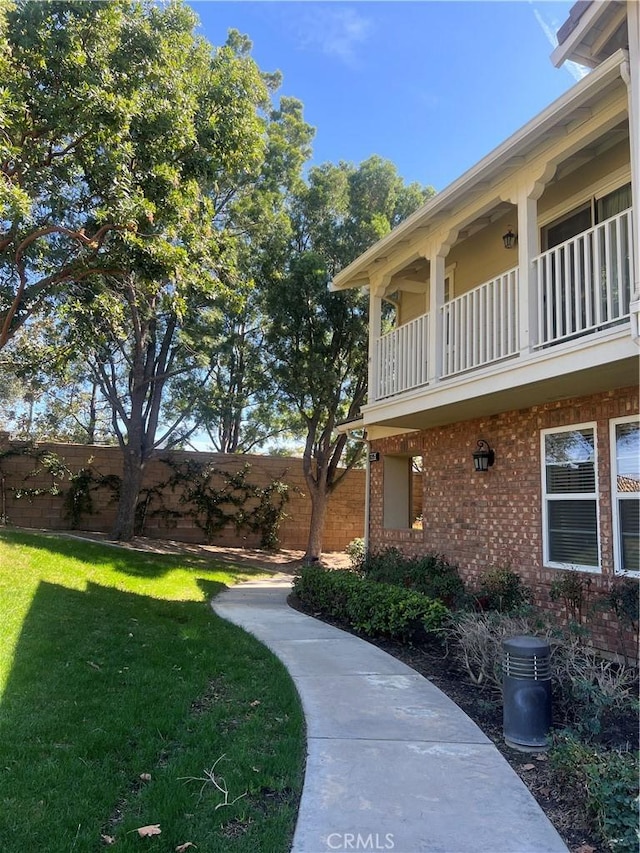 view of yard with fence and a balcony