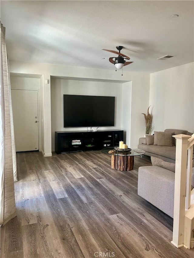 unfurnished living room featuring baseboards, ceiling fan, visible vents, and wood finished floors