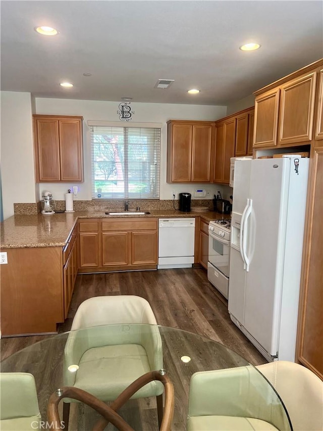 kitchen featuring dark wood finished floors, recessed lighting, visible vents, a sink, and white appliances