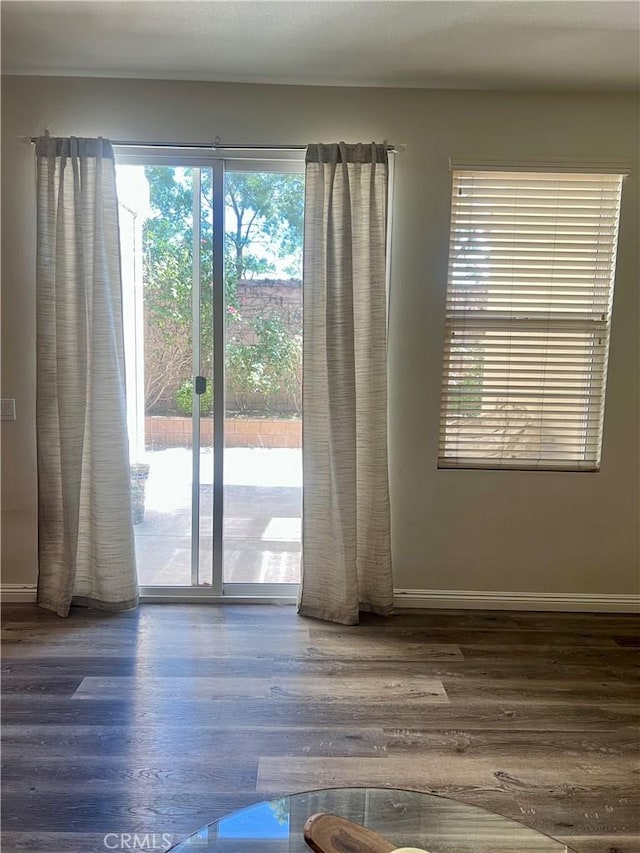 empty room with baseboards and wood finished floors