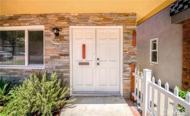 entrance to property with stone siding and stucco siding