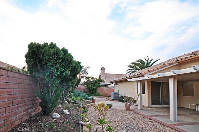 view of yard featuring central AC, a patio area, and a fenced backyard