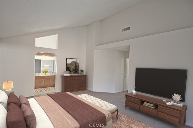 bedroom featuring visible vents, carpet flooring, ensuite bathroom, and lofted ceiling