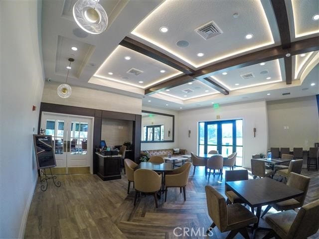 dining space featuring french doors, visible vents, and coffered ceiling