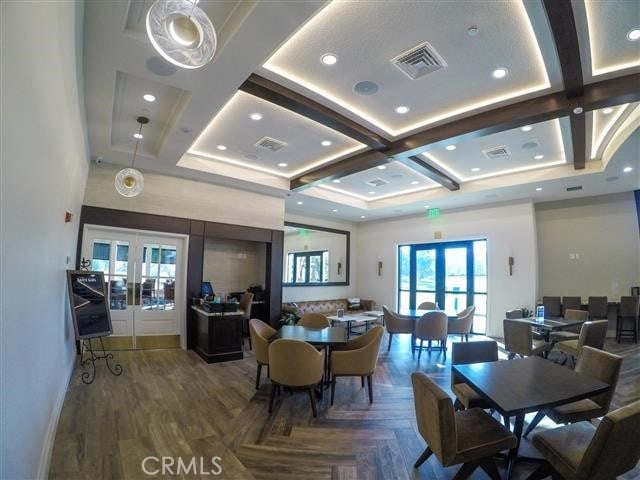 dining room with visible vents, french doors, coffered ceiling, and a towering ceiling