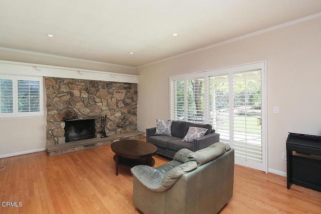 living room featuring baseboards, ornamental molding, a fireplace, and light wood-style floors