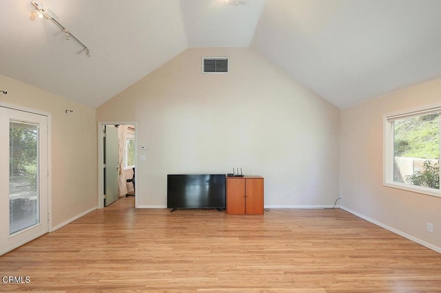 unfurnished living room featuring light wood-style flooring, track lighting, visible vents, and baseboards