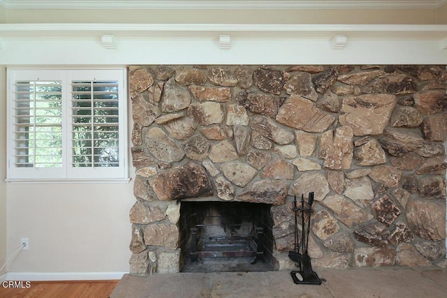 room details with crown molding, a fireplace, wood finished floors, and baseboards