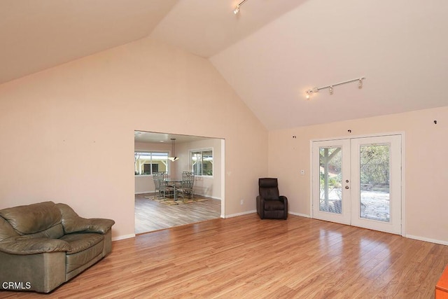 unfurnished room with plenty of natural light, wood finished floors, and french doors