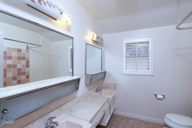 bathroom featuring a shower, toilet, a sink, tile patterned flooring, and baseboards