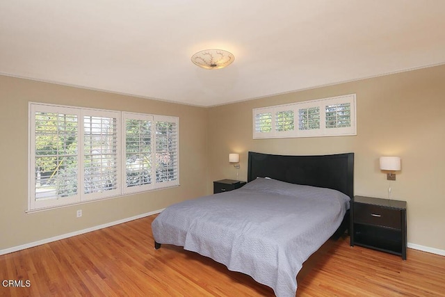 bedroom with light wood-style flooring and baseboards