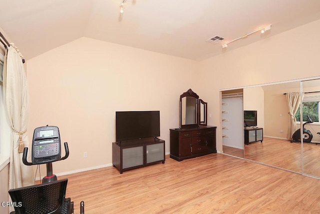 bedroom with lofted ceiling, light wood-style flooring, visible vents, and track lighting