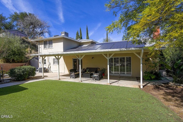 rear view of house featuring outdoor lounge area, a patio area, stucco siding, and a yard