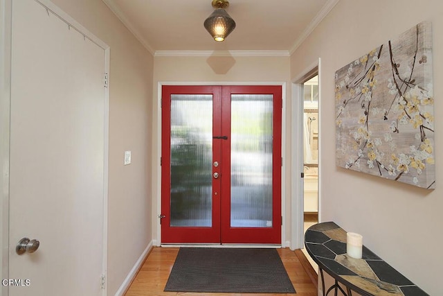 entryway with baseboards, wood finished floors, crown molding, and french doors