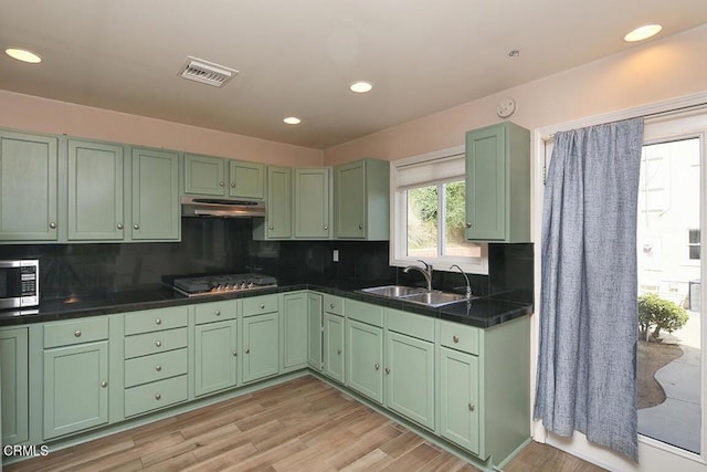 kitchen with visible vents, green cabinetry, appliances with stainless steel finishes, under cabinet range hood, and a sink