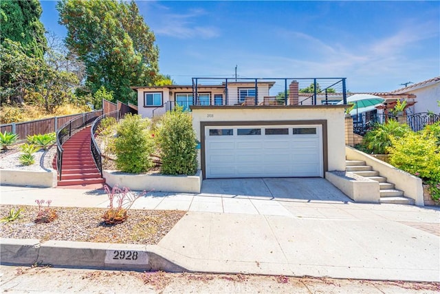 view of front of property with a garage, stairway, and stucco siding