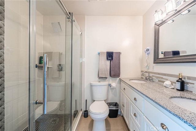 full bathroom featuring a sink, a shower stall, toilet, and tile patterned floors