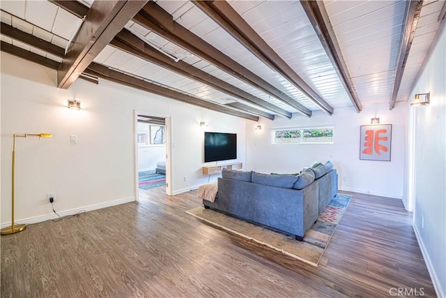 living area with baseboards, beam ceiling, and wood finished floors