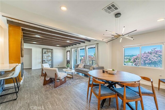 dining area with visible vents, beamed ceiling, baseboards, and wood finished floors