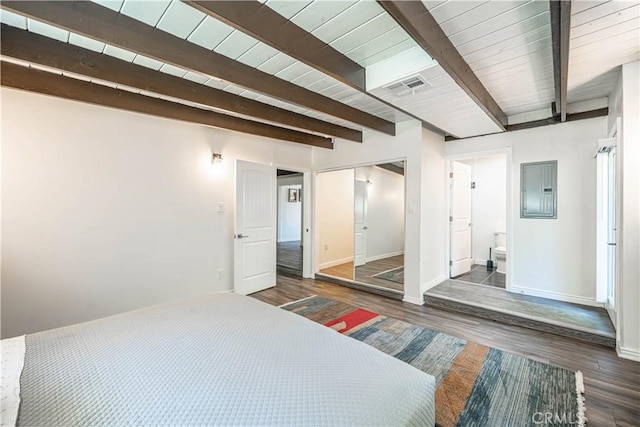 bedroom featuring beam ceiling, visible vents, and wood finished floors