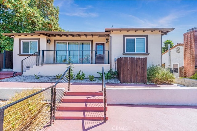 view of front of house featuring fence and stucco siding