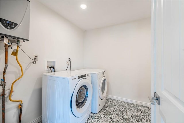 washroom featuring laundry area, light tile patterned floors, baseboards, washing machine and clothes dryer, and water heater