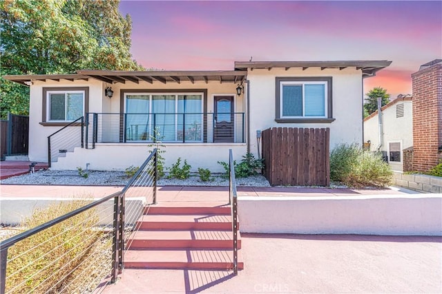 view of front of home featuring fence and stucco siding