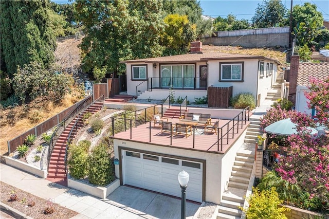 view of front of house featuring a garage, stairway, and stucco siding