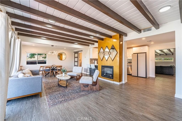 living room with visible vents, a fireplace, baseboards, and wood finished floors