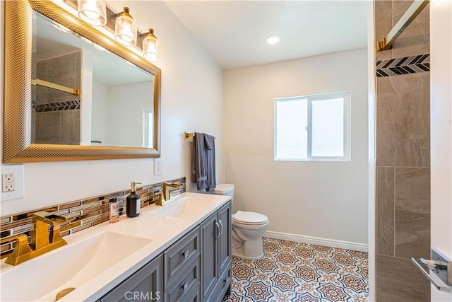 bathroom with baseboards, backsplash, a sink, and tiled shower