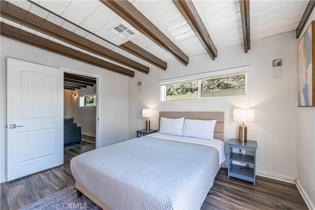 bedroom featuring beamed ceiling, multiple windows, wood finished floors, and visible vents