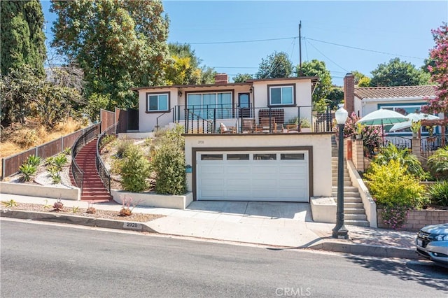 view of front of home with concrete driveway, stairway, an attached garage, and stucco siding