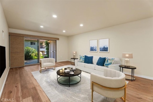 living room with baseboards, light wood finished floors, and recessed lighting