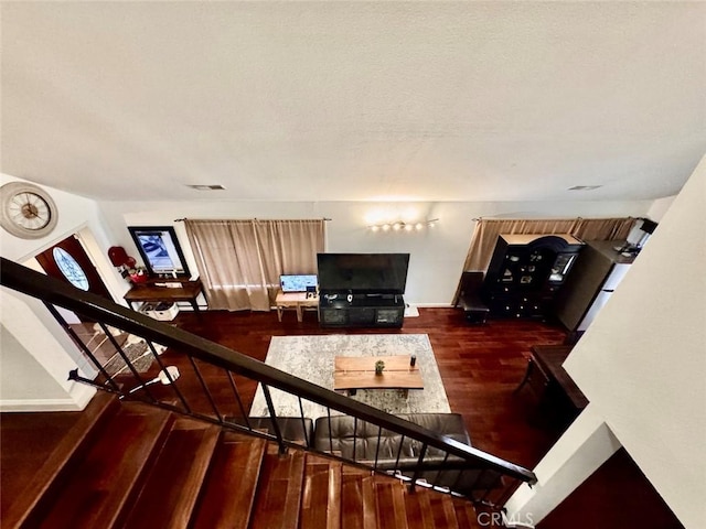 interior space with a textured ceiling, wood finished floors, and visible vents